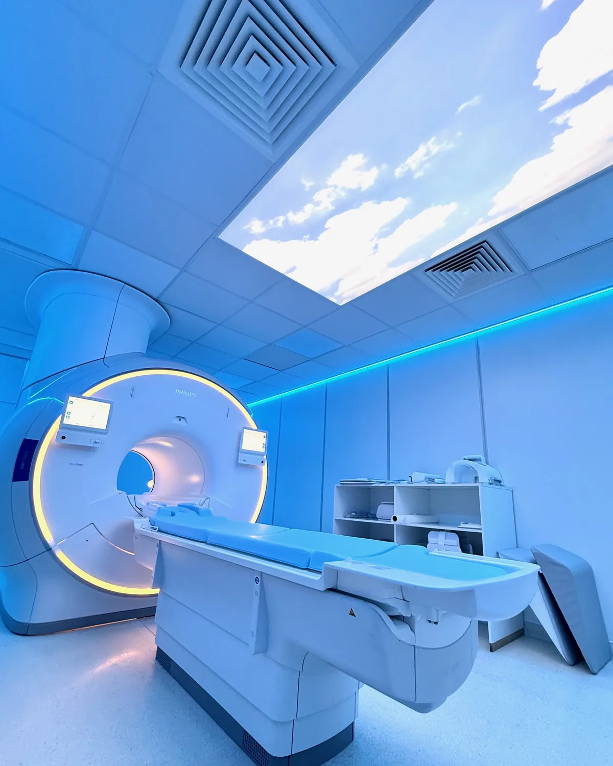 Sala de ressonância magnética renovada da CRMA, em Faro: o equipamento Philips MR 5300 com iluminação ambiente e um painel de céu no teto